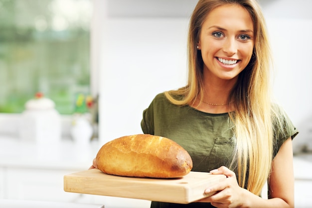 mujer con hogaza de pan en la cocina