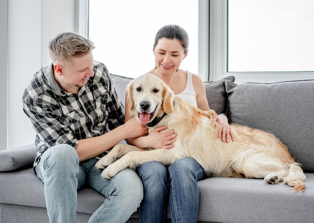 Mujer y hombre abrazando lindo perro