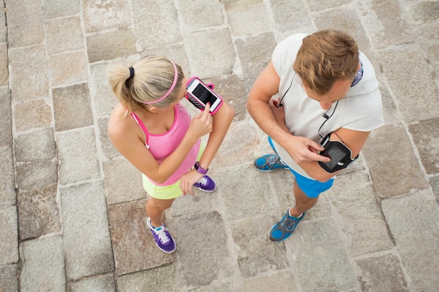 Mujer y hombre configurando sus teléfonos antes del entrenamiento