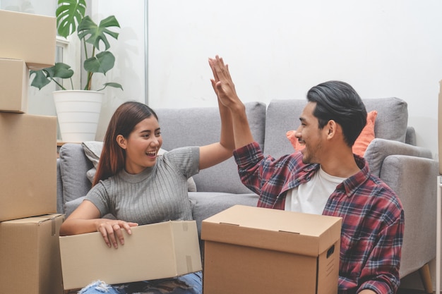 Foto mujer y hombre desempacando cajas desordenadas después de mudarse juntas en una casa nueva.