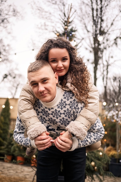 Una mujer y un hombre están parados cerca del árbol de Navidad, están felices, el estado de ánimo de año nuevo