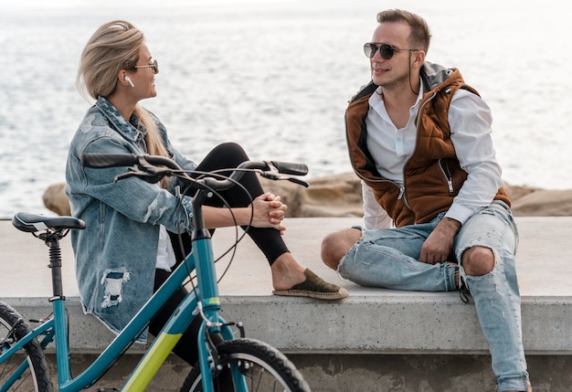 Foto mujer y hombre hablando junto a una bicicleta