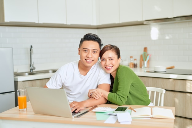 Mujer y hombre haciendo trámites juntos, pagando impuestos en línea en un equipo portátil