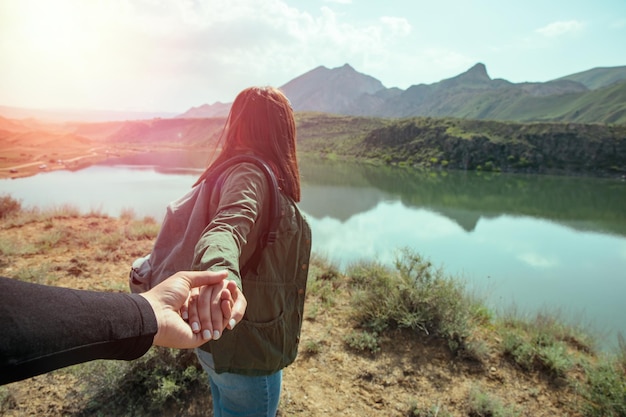 Mujer y hombre de la mano cerca del lago