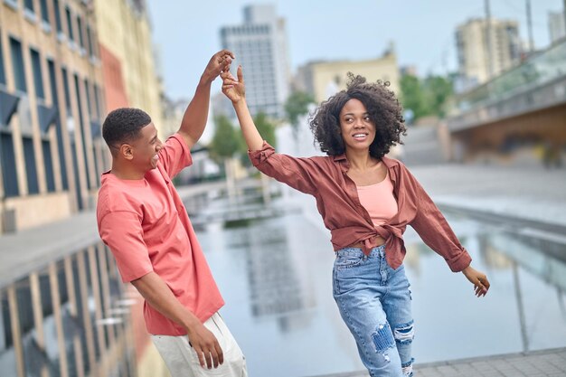 Mujer y hombre con la mano levantada en movimiento de baile.