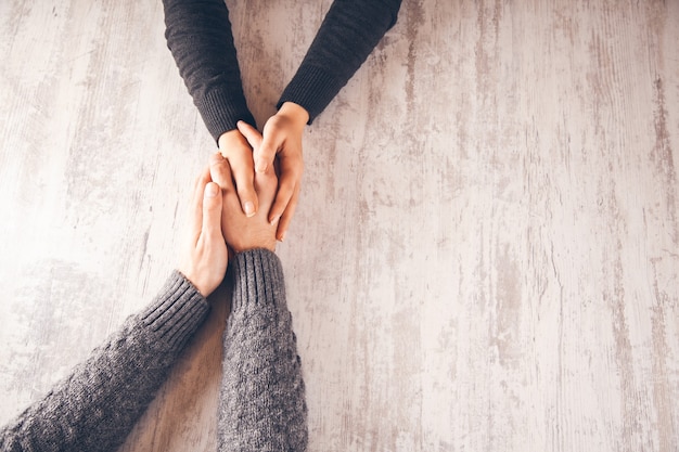 Foto mujer y hombre de la mano en la mesa de madera