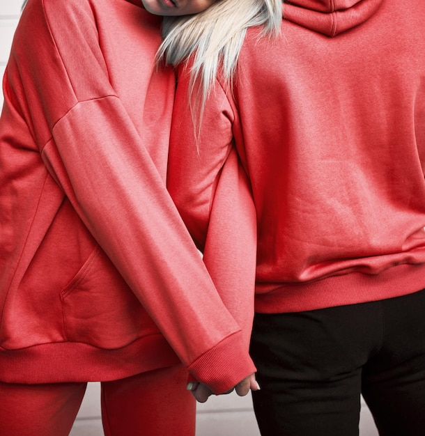 Mujer y hombre de pie en sudaderas rojas Sudadera con capucha burdeos en el modelo