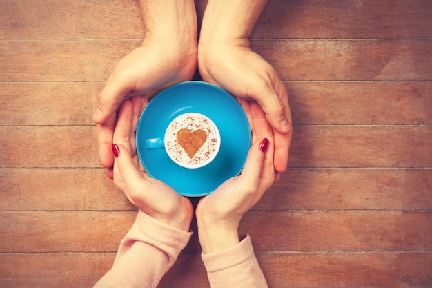 Mujer y hombre sosteniendo una taza de café