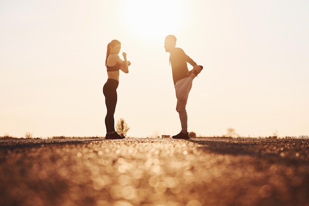 Mujer y hombre tienen un día de fitness en la carretera por la noche juntos