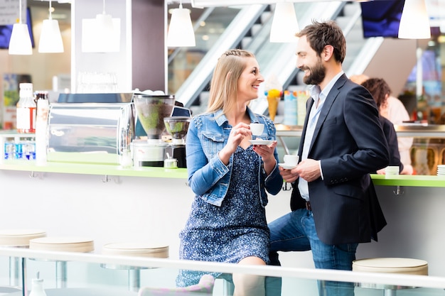 Mujer y hombre tomando café en café