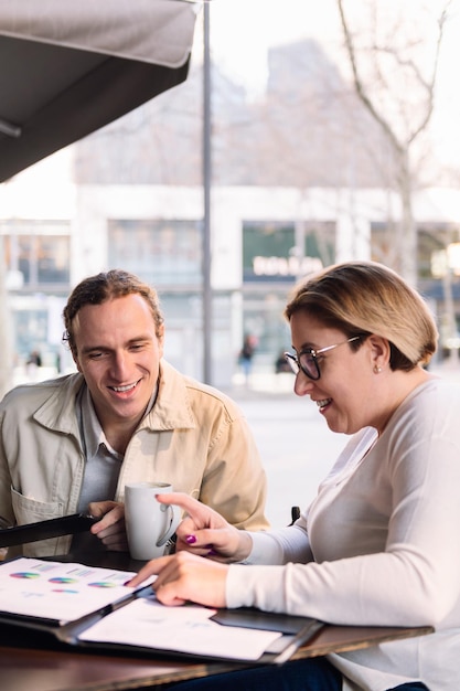 Mujer y hombre trabajando juntos mientras toman café