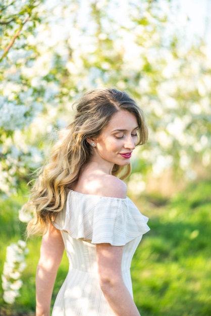 Mujer en huerto de cerezos en flor en primavera