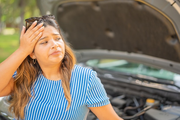 Foto mujer impaciente esperando asistencia mecánica para ayudarla con su coche debido a un problema mecánico