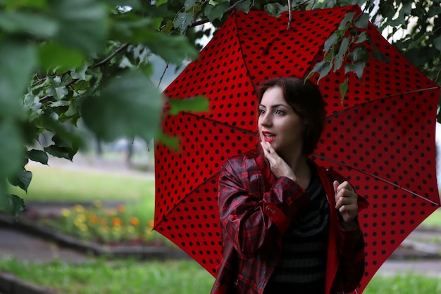mujer en un impermeable y un paraguas