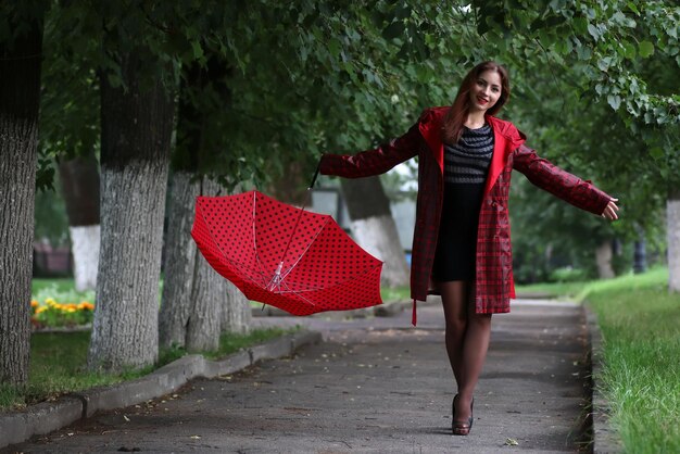 mujer en un impermeable y un paraguas