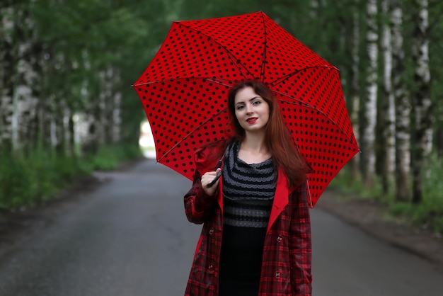 mujer en un impermeable y un paraguas