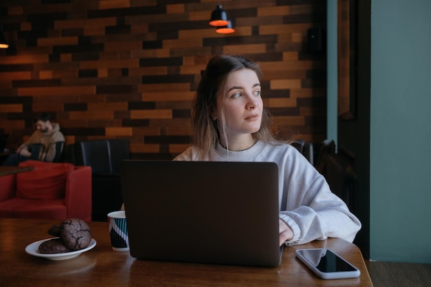 Mujer independiente feliz trabajando en un café de forma remota