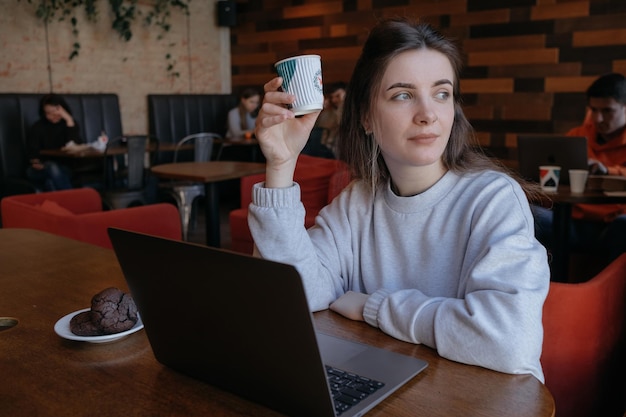 Mujer independiente feliz trabajando en un café de forma remota