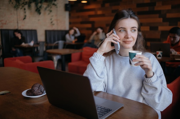 Mujer independiente feliz trabajando en un café de forma remota