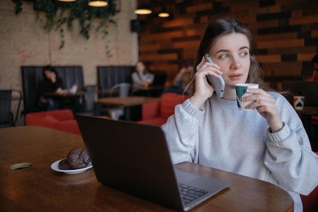 Mujer independiente feliz trabajando en un café de forma remota