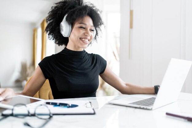 La mujer independiente trabaja con documentos en línea en la computadora portátil del lugar de trabajo de la oficina en la mesa de finanzas en la empresa