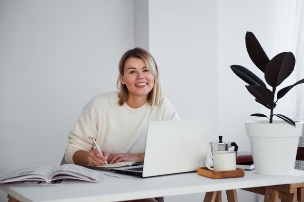 mujer independiente trabajando en línea en la mesa usando la computadora