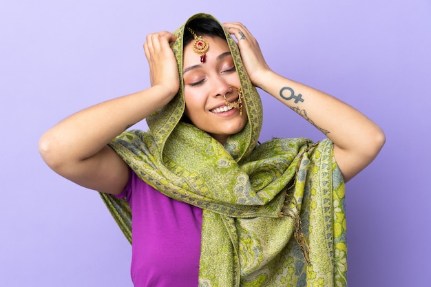 Mujer india aislada sobre fondo púrpura riendo