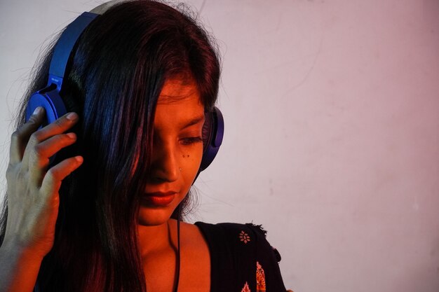 Foto una mujer india escuchando música.
