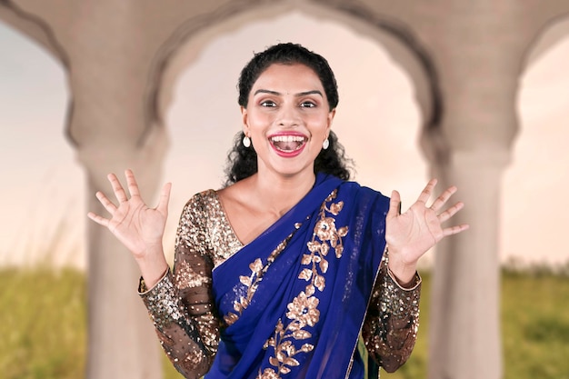 Una mujer india feliz lleva un vestido de saree azul