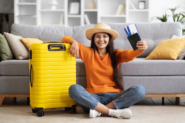 Mujer india feliz yendo de vacaciones mostrando boletos de avión