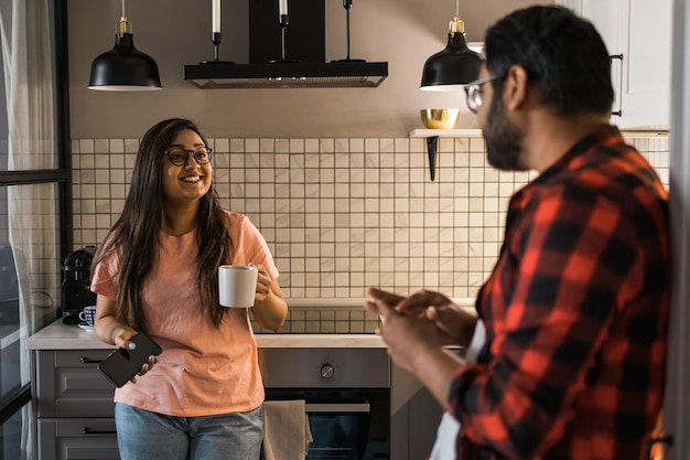 Mujer india hablando con un hombre latino en la cocina Estilo de vida alimentación saludable concepto multiétnico