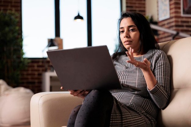 Mujer india hablando en una llamada de teleconferencia en línea con cámara web, reuniéndose con colegas en un chat de videollamada virtual. Charlando por videoconferencia remota, trabajo de telecomunicaciones desde casa.