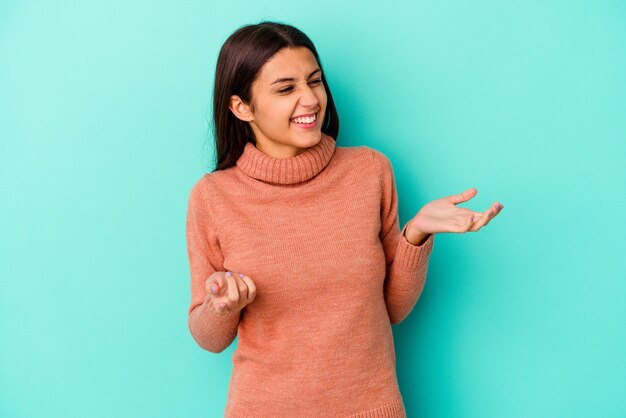 Mujer india joven aislada en la pared azul alegre riendo mucho. Concepto de felicidad.