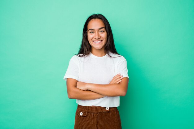 Mujer india joven de raza mixta aislada que se siente segura, cruzando los brazos con determinación.