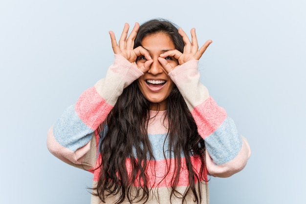 Mujer India moda joven mostrando signo bien sobre los ojos