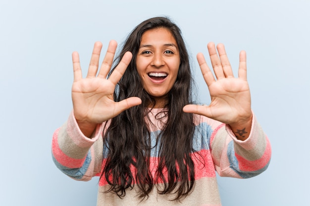 Mujer india de la moda de los jóvenes que muestra el número diez con las manos.