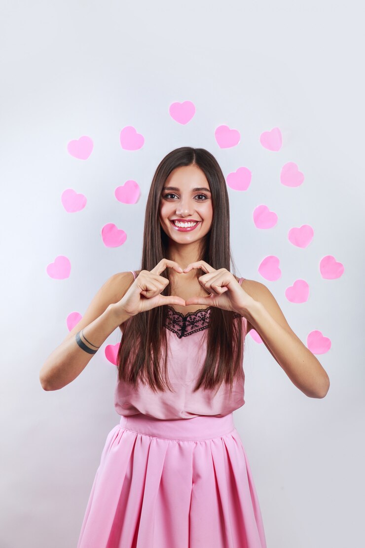 Foto mujer india morena joven bastante romántica que hace un gesto del corazón con sus dedos delante. concepto de día de san valentín
