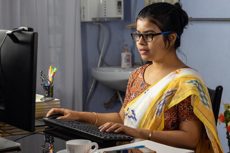 Foto mujer india en saree trabajando en la computadora en casa trabajo desde casa concepto