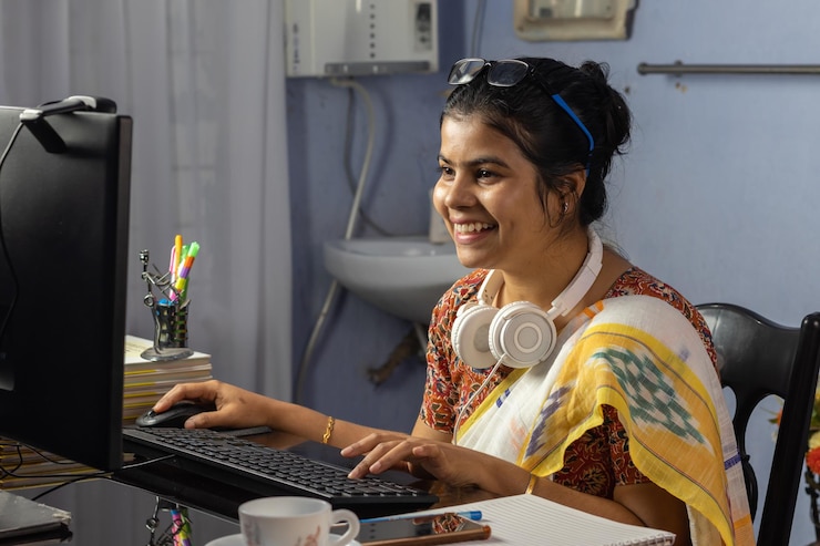 Foto mujer india en saree trabajando en la computadora y hablando por internet desde casa enseñando en línea