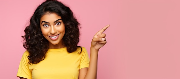 Mujer india sonriente con ropa informal señalando con el dedo índice