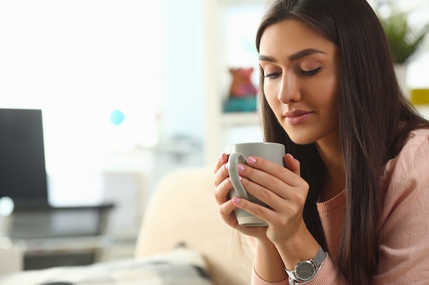 Foto la mujer india sostiene la taza sus sonrisas de la mano