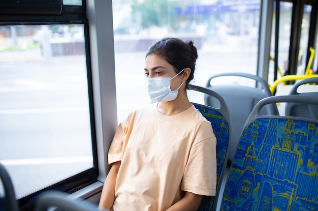 Mujer india viaje en autobús de transporte público en mascarilla médica