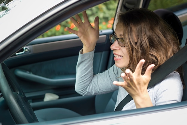 Foto una mujer está indignada sentada en el automóvil.