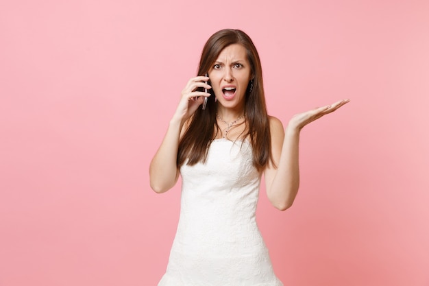 Mujer indignada en vestido blanco hablando por teléfono móvil, jurando