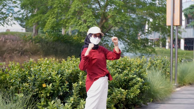 Mujer indonesia apretando los puños mostrando alegría mientras celebra el día de la independencia en el parque