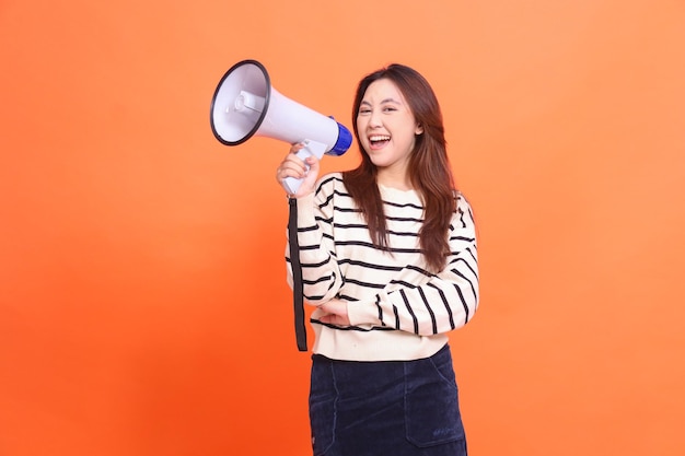 mujer indonesia expresión alegre gritando en la cámara de pie sosteniendo un altavoz de megáfono