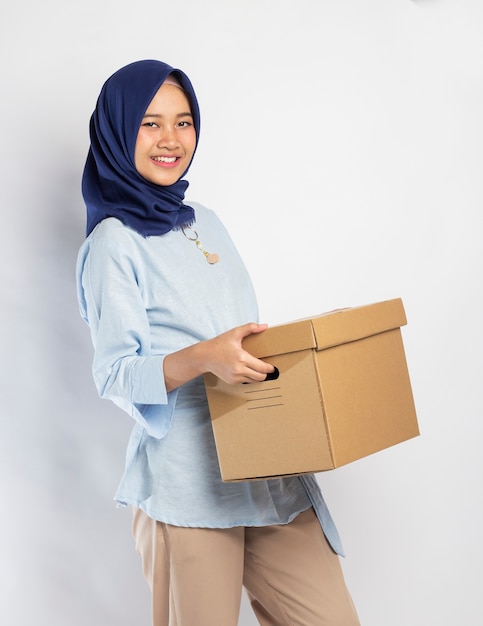 Mujer indonesia en hijab levantando una caja