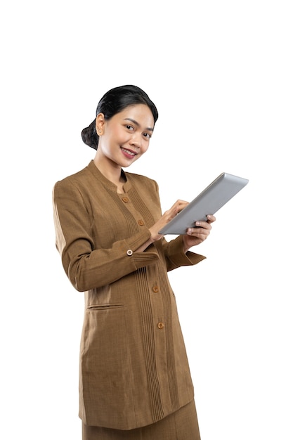 Mujer indonesia en uniforme de funcionario con los pulgares hacia arriba mientras usa la tableta