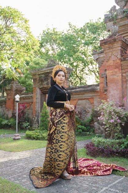 Mujer indonesia vistiendo kebaya balinesa y telas tejidas