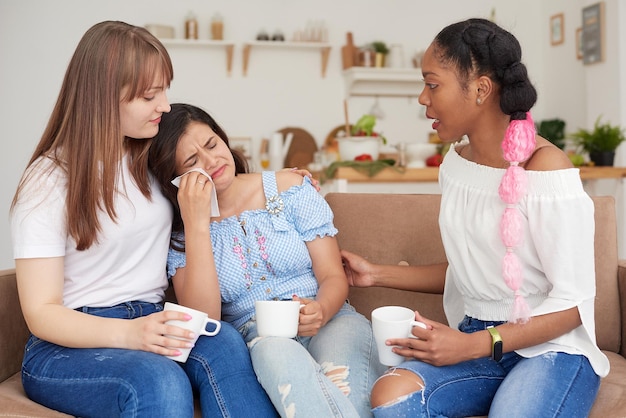 Una mujer infeliz habla de sus problemas con sus amigos en casa El concepto de amistad y apoyo